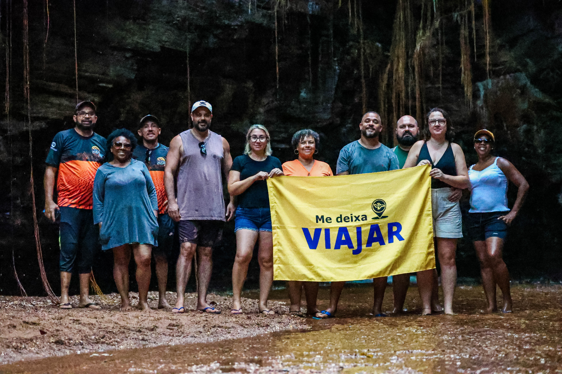 Grupo de viajantes da Me Deixa Viajar com bandeira em caverna do Jalapão